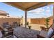 Covered patio with comfortable seating, brick pavers, and a well-maintained backyard area at 10951 Stone Crossing Ave, Las Vegas, NV 89166