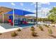 Playground area featuring slides, benches, covered picnic area, and greenery at 10951 Stone Crossing Ave, Las Vegas, NV 89166