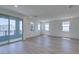 Spacious living room with hardwood floors, large sliding glass doors, and multiple windows at 11552 Ashy Storm Ave, Las Vegas, NV 89138