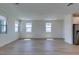 Bright and airy living room showcasing wood-look floors and multiple windows, offering ample natural light at 11552 Ashy Storm Ave, Las Vegas, NV 89138