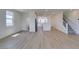 Open-concept living room featuring wood-look flooring, modern finishes, and seamless transition to the kitchen and stairway at 11552 Ashy Storm Ave, Las Vegas, NV 89138