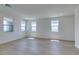Bright and spacious living room featuring wood-look floors and plenty of natural light from the large windows at 11552 Ashy Storm Ave, Las Vegas, NV 89138