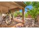 Covered patio featuring comfortable seating, a hanging swing, and a well-maintained yard at 11625 Cabo Del Verde Ave, Las Vegas, NV 89138