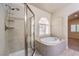 Bathroom featuring glass-enclosed shower and separate tub with tile surround at 11625 Cabo Del Verde Ave, Las Vegas, NV 89138