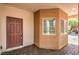 Inviting front entrance to a home featuring a dark brown door with brick pavers and unique window at 11625 Cabo Del Verde Ave, Las Vegas, NV 89138
