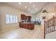 Inviting kitchen with dark wood cabinetry, granite counters, stainless appliances, and staircase at 11625 Cabo Del Verde Ave, Las Vegas, NV 89138