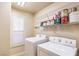 Laundry room with washer, dryer, window with shutters, and shelving at 11625 Cabo Del Verde Ave, Las Vegas, NV 89138