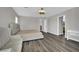 Bright bedroom with hardwood floors, neutral walls, a large bed, a sofa, and a bright desk at 11787 Fern Creek Ln, Las Vegas, NV 89183