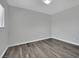 Empty bedroom featuring wood-look floors, white trim, and a neutral color scheme at 11787 Fern Creek Ln, Las Vegas, NV 89183