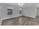 Well-lit living room with wood floors and two windows at 11787 Fern Creek Ln, Las Vegas, NV 89183