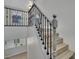 Modern staircase featuring wood steps, decorative iron railings, and natural light at 11787 Fern Creek Ln, Las Vegas, NV 89183
