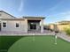 Cozy backyard showing the putting green, covered patio, and brick pavers, ideal for enjoying outdoor living and recreation at 12565 Huckleberry Oak Ave, Las Vegas, NV 89138