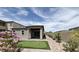 A backyard with flowerbeds, artificial grass putting green and a covered patio at 12565 Huckleberry Oak Ave, Las Vegas, NV 89138