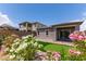 A serene backyard with a putting green, brick patio, and flowering bushes at 12565 Huckleberry Oak Ave, Las Vegas, NV 89138