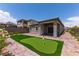 Backyard with a custom putting green, brick patio, and lush, colorful landscaping at 12565 Huckleberry Oak Ave, Las Vegas, NV 89138