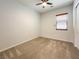 A simple bedroom with neutral walls and carpeting, a window with blinds, and a ceiling fan at 12565 Huckleberry Oak Ave, Las Vegas, NV 89138