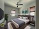 This staged bedroom has a soft bed, modern decor, and large windows for ample light at 12565 Huckleberry Oak Ave, Las Vegas, NV 89138