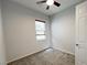 Empty bedroom features neutral walls, plush carpeting, a window with blinds, and a ceiling fan at 12565 Huckleberry Oak Ave, Las Vegas, NV 89138