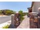 Inviting entrance with stone pillars, iron gate, and landscaped pathway at 12565 Huckleberry Oak Ave, Las Vegas, NV 89138
