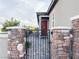 Charming front entrance featuring a secure gate and decorative stone pillars at 12565 Huckleberry Oak Ave, Las Vegas, NV 89138