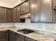 Close up of the kitchen featuring granite countertops, stainless steel hood vent, and gas cooktop at 12565 Huckleberry Oak Ave, Las Vegas, NV 89138