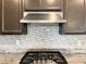 Close-up of a gourmet kitchen featuring stainless steel appliances, mosaic backsplash, and granite countertops at 12565 Huckleberry Oak Ave, Las Vegas, NV 89138