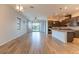 Bright living room with wood floors, modern lighting, and open layout to the kitchen at 12565 Huckleberry Oak Ave, Las Vegas, NV 89138