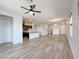 Spacious living room featuring wood-look tile flooring, ceiling fan, and an open floor plan into the kitchen at 12565 Huckleberry Oak Ave, Las Vegas, NV 89138