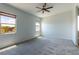 Spacious carpeted main bedroom featuring two windows that provide ample natural light and a ceiling fan at 12565 Huckleberry Oak Ave, Las Vegas, NV 89138