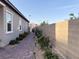 Side yard showing the brick paver pathway with flowering bushes and ambient lighting, offering an inviting walkway at 12565 Huckleberry Oak Ave, Las Vegas, NV 89138