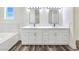 Bright bathroom featuring double sinks and mirrors, a luxurious tub with marble-look tiles at 1351 Huckleberry St, Pahrump, NV 89048