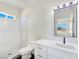 Bathroom featuring single sink vanity with a framed mirror, and marble-look tiled shower at 1351 Huckleberry St, Pahrump, NV 89048
