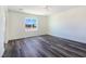 Bright bedroom featuring wood-look floors, a ceiling fan, a window with a view, and a closet with mirror doors at 1351 Huckleberry St, Pahrump, NV 89048
