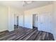 Bright bedroom featuring wood-look floors, a ceiling fan, a window with a view, and a closet with mirror doors at 1351 Huckleberry St, Pahrump, NV 89048
