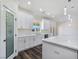 Open kitchen featuring white cabinets, marble countertops, stylish pendant lighting, and a convenient pantry at 1351 Huckleberry St, Pahrump, NV 89048