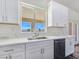 Modern kitchen sink with a view, white cabinets, marble countertops, and a dishwasher for convenience at 1351 Huckleberry St, Pahrump, NV 89048
