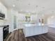 Modern kitchen features white cabinetry, stainless steel appliances, a large island and luxury vinyl plank flooring at 1351 Huckleberry St, Pahrump, NV 89048