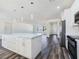Bright, open kitchen featuring white cabinets, a large island, and modern appliances, open to living area at 1351 Huckleberry St, Pahrump, NV 89048