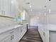 Bright kitchen featuring white cabinets, quartz countertops, a large island, and wood floors at 1351 Huckleberry St, Pahrump, NV 89048