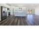 Bright kitchen featuring white cabinets, stainless steel appliances, an island and luxury vinyl plank flooring at 1351 Huckleberry St, Pahrump, NV 89048