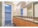 Bathroom featuring dual sinks, granite counters, and modern fixtures, with a walk-in closet view at 1448 Canyon Ledge Ct, Las Vegas, NV 89117