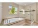 Modern bathroom showcasing a soaking tub and glass-enclosed shower with tile accents at 1448 Canyon Ledge Ct, Las Vegas, NV 89117