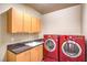 A modern laundry room features vibrant red washer and dryer and ample counter space at 1448 Canyon Ledge Ct, Las Vegas, NV 89117