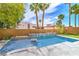 A tranquil backyard oasis with lush palm trees, a water feature and sparkling blue pool at 1448 Canyon Ledge Ct, Las Vegas, NV 89117