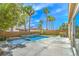 Relax in this backyard pool, surrounded by lush palm trees and a water feature at 1448 Canyon Ledge Ct, Las Vegas, NV 89117