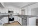 Modern kitchen with stainless steel appliances, white cabinetry, granite countertops, and a breakfast bar for casual dining at 1505 Blackcombe St # 202, Las Vegas, NV 89128