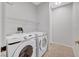 Functional laundry room featuring a side-by-side washer and dryer set with overhead shelving for storage solutions at 1505 Blackcombe St # 202, Las Vegas, NV 89128