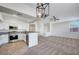 Bright open-concept living space featuring a modern kitchen with stainless steel appliances and a spacious carpeted living area at 1505 Blackcombe St # 202, Las Vegas, NV 89128