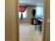 Open living space with a glimpse into the kitchen, featuring neutral carpeting at 152 Lotus Vale Ave, Las Vegas, NV 89123