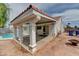 View of the covered patio and pool area in this backyard with a terracotta tile roof and mature trees at 1523 Silver Point Ave, Las Vegas, NV 89123